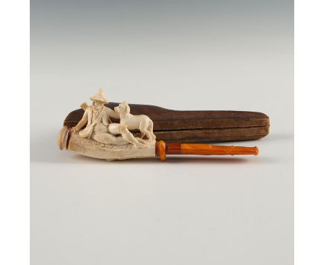 Highly detailed carving of huntsman, hound, foliage. Amber stem.A very unusual hand carved Meerschaum pipe, with a front-load