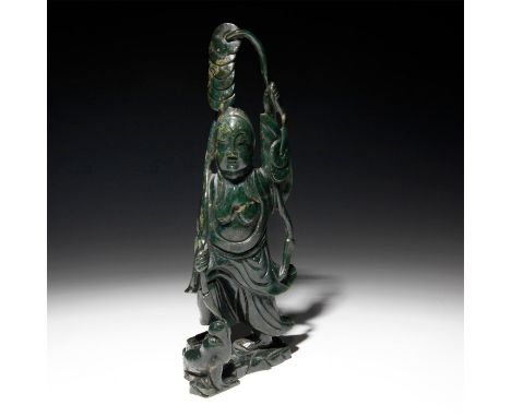 Striking dark green jade.Carved into a likeness of a Chinese divinity holding various ceremonial implements, with a baby at h