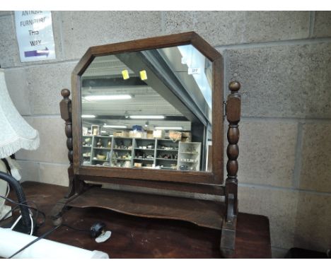 An early 20th century oak toilet/swing mirror having bobbin frame