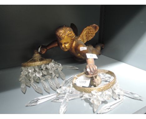A plaster cast figural light of a cherub holding twin lights