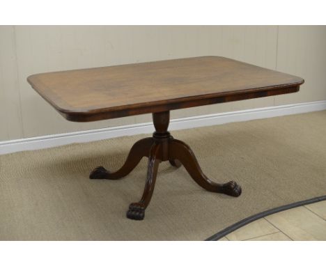 A Regency oak Breakfast Table with rectangular top having mahogany cross-banding on vase turned column, quadruple splay base 