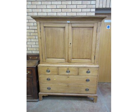 A 19th Century polished pine Press Cupboard with pair of fielded panelled doors enclosing shelves, two short and two long dra