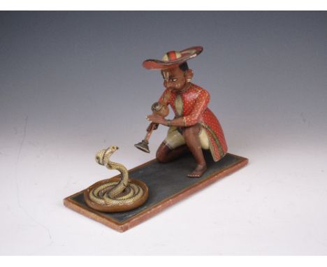 A 19th Century South Indian wood Figurine, c. 1860, painted and varnished, of a kneeling snake charmer playing a pipe to a co