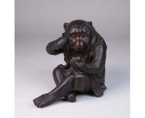 A Japanese bronze Okimono of a Nihonzaru, wearing a jacket and examining a netsuke, bears 3-character signature, 6in H (lacks