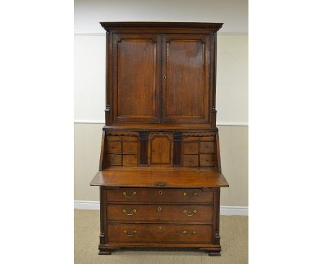 A Georgian oak Bureau Cabinet, the upper section with dentil cornice above pair of cross-banded solid panelled doors, the bur