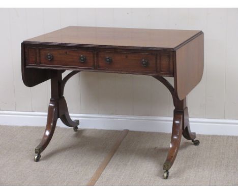 A Regency mahogany Sofa Table fitted two frieze drawers on cheval base and brass casters