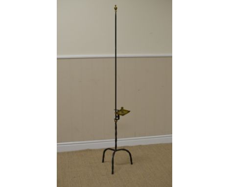 An antique wrought iron Candle Holder with brass nozzle and square drip pan on spiral column and tripod base