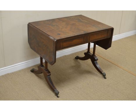 A Regency mahogany Sofa Table with ebonised stringing and inlay, fitted two frieze drawers on cheval base with brass claw cap