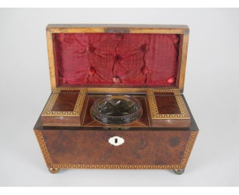 A Regency yew wood Tea Caddy of sarcophagus shape with satinwood cross-banding and Greek key inlay, two interior lidded divis