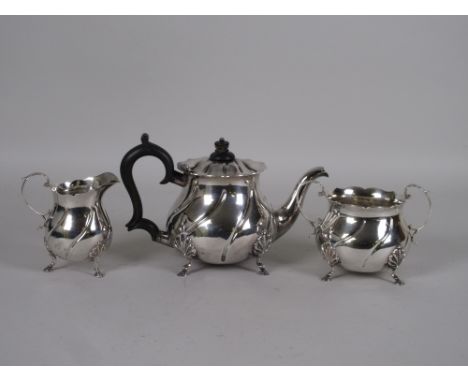 A late Victorian silver three piece Tea Service with shell decoration and hoof supports viz: Teapot, Sucrier and Milk Jug, Lo