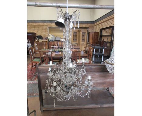 A two tier eight branch Chandelier with central glass column, metal branches united by swags of baguettes centred by pear dro