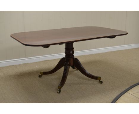 A Regency mahogany Breakfast Table with rectangular top having satinwood banding and stringing on turned column and reeded qu