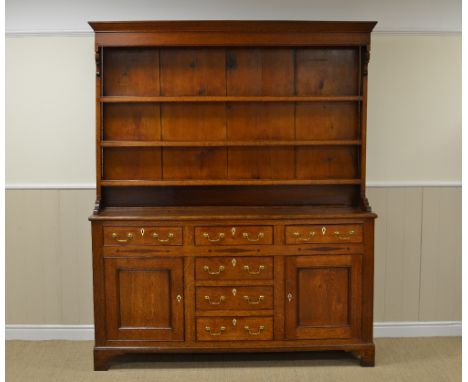 A Georgian Anglesey oak Dresser with boarded rack, the enclosed base fitted three drawers above inlaid frieze, three further 