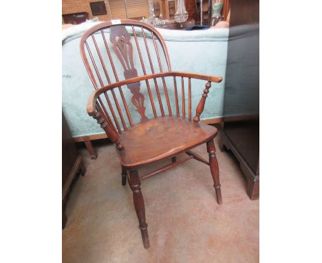 A 19th Century Windsor Elbow Chair with pierced splat and stick back, solid seat on turned legs united by H stretcher