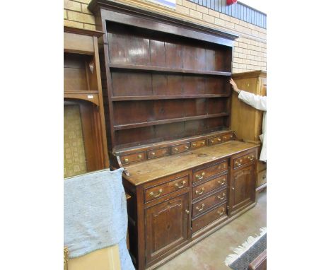 An 18th Century oak Dresser with boarded rack fitted two small cupboards above a row of six spice drawers, the base fitted si