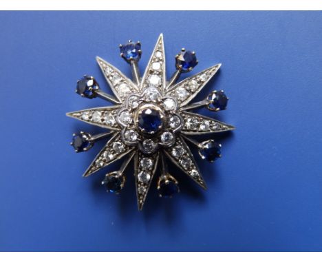 A sapphire &amp; diamond set star brooch in yellow metal with silver facings,  1.5" diameter.