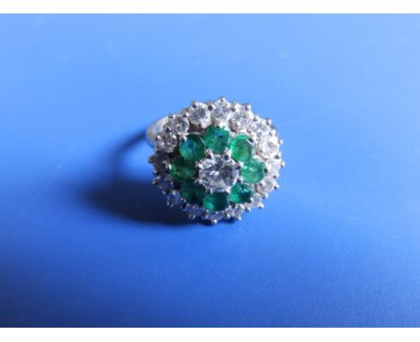 A modern emerald &amp; diamond target cluster ring, total diamond weight approximately 1.5 carats in '18ct' white metal. Fing