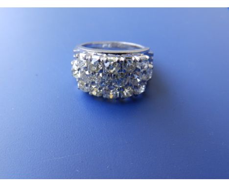 A modern Chinese diamond set '18k' white metal ring, the 16 old cut stones very slightly off white in colour, arranged in thr