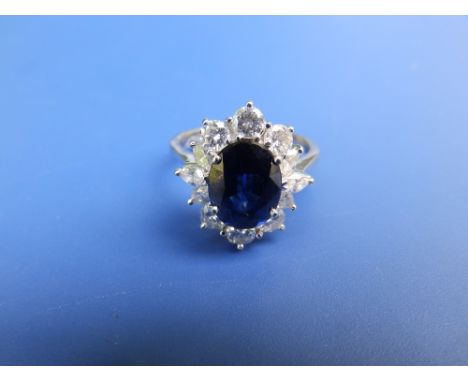 A modern sapphire &amp; diamond oval cluster ring in 18ct white gold, the sapphire weighing approximately 2.8 carats, total d