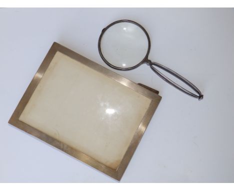 A silver folding magnifying glass - JCV, London 1914, 8" overall and a plain silver photo frame - WA, Birmingham 1937. (2)