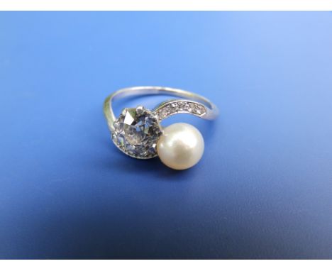 An Edwardian diamond &amp; pearl crossover set ring, the old cut diamond weighing approximately 1.5 carats, small diamonds to