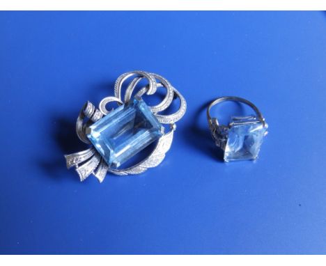 A '9c' white metal swag brooch set with a large rectangular cut pale blue stone,  the stone measuring 24mm x 17mm together wi