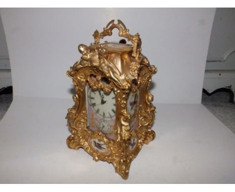 A reproduction gilt metal repeating mantel clock with painted porcelain panels,  9.5" overall.