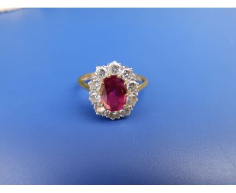 A ruby &amp; diamond set oval cluster ring, the ruby weighing approximately 2.1 carats, total diamond weight approximately on