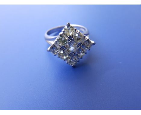 A modern Chinese diamond set '18k' white metal ring, the nine old cut stones, slightly off white in colour, arranged in lozen