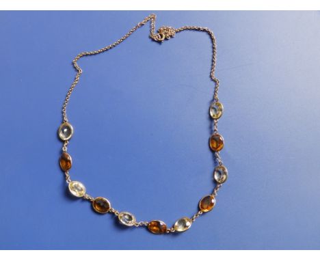 A '9c' necklace set with 11 oval cut citrine coloured stones of alternating light &amp; dark shades.