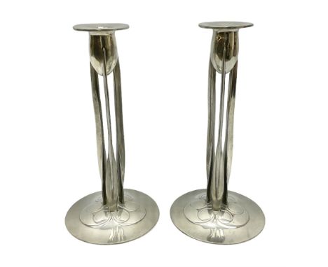 Archibald Knox (1864-1933) for Liberty &amp; Co, pair of Tudric pewter candlesticks, the bud shaped sockets raised upon three