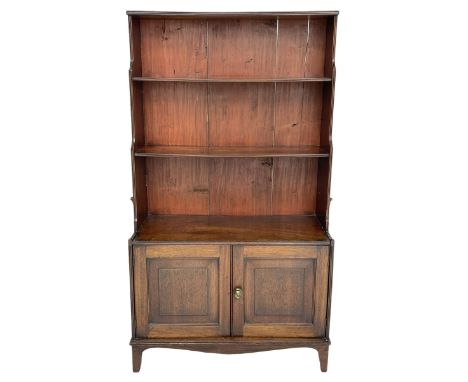 George III mahogany waterfall bookcase on cupboard, three raised shelves over double cupboard, enclosed by two panelled doors
