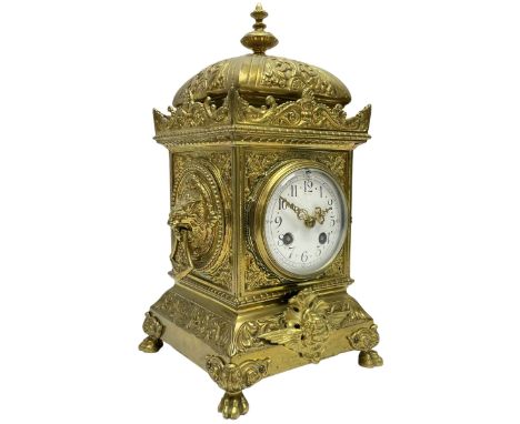 A French twin train striking mantle clock c1890 in a brass case with a decorative plinth raised on four paw feet, pediment wi