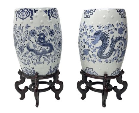Pair of Chinese blue and white garden seats, each of barrel form, decorated with dragon and phoenix amidst flowering vines, e