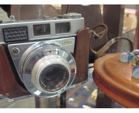 A solitaire board and marbles, a metronome and a vintage kodak camera  