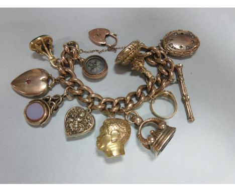 A charm bracelet with heart locket clasp and eleven pendant charms, the chunky curb link bracelet of rose precious metal susp