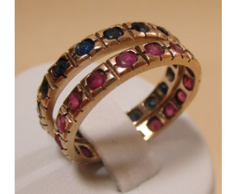 A pair of sapphire and ruby full hoop rings, the small round stones in rubover settings, both set in unmarked yellow precious