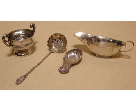 A silver shell shaped caddy spoon, a sauce boat, a small twin handled cup and a silver sugar sifter spoon, London 1862, 4.3oz