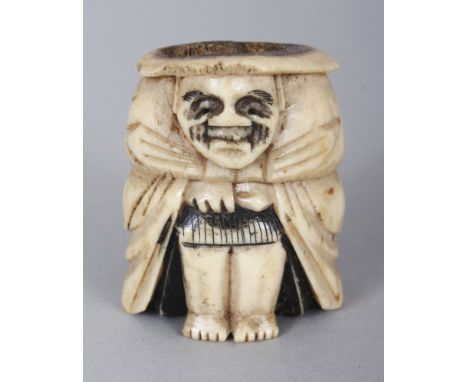 A JAPANESE MEIJI PERIOD STAGHORN NETSUKE OF DARUMA, squatting with his cloak closely drawn, 1.4in high.