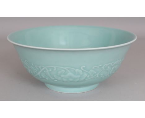 A GOOD QUALITY CHINESE CELADON PORCELAIN BOWL, the sides moulded in relief beneath the glaze with a band of formal scrolling 