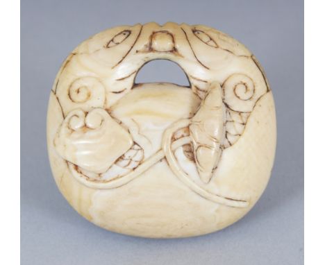 AN UNUSUAL JAPANESE MEIJI PERIOD IVORY NETSUKE OF A MOKUGYO TEMPLE DRUM, entwined with lotus and lingzhi, the himotoshi forme