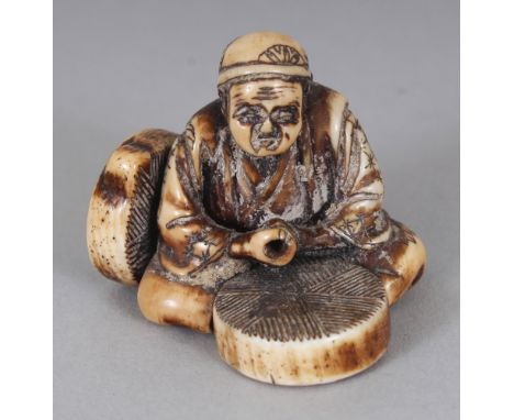 A SIGNED JAPANESE MEIJI PERIOD STAINED IVORY NETSUKE OF A SEATED ARTISAN, the base with an engraved signature, 1.1in high.