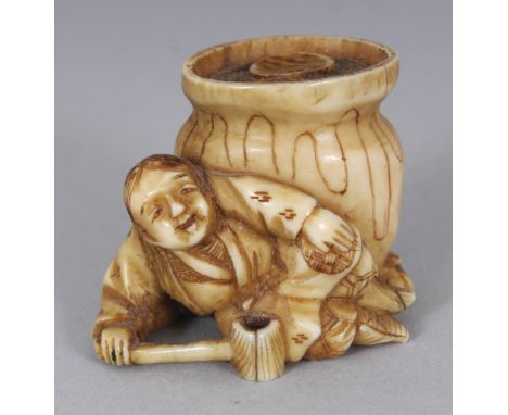 A JAPANESE MEIJI PERIOD STAINED IVORY NETSUKE OF A MAN RECLINING BEFORE A CAULDRON, his ladle forming the himotoshi, 1.3in wi