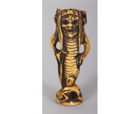 A SIGNED JAPANESE MEIJI PERIOD STAINED IVORY NETSUKE OF AN ONI MERMAN, the base with an engraved signature, 2.4in high.