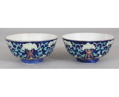 A SMALL PAIR OF CHINESE TONGZHI MARK & PERIOD BLUE GROUND PORCELAIN BOWLS, each painted with scrolling lotus, bats and Shou c