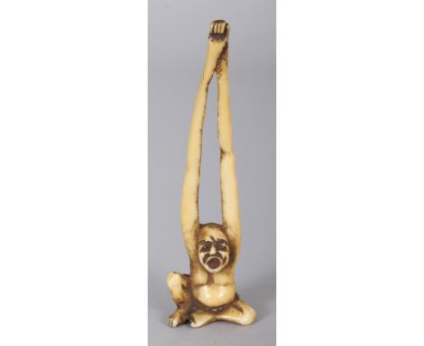 A JAPANESE MEIJI PERIOD STAINED IVORY NETSUKE OF TENAGA, his long arms stretched out above his head and forming the himotoshi