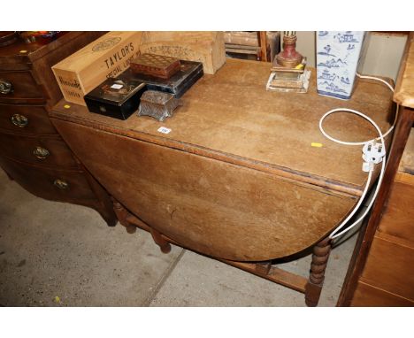 An oak gate leg dining table on barley twist supports 