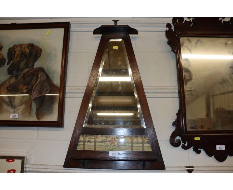 An Arts &amp; Crafts oak framed bevelled wall mirror inset with a equestrian scene and pipe rack