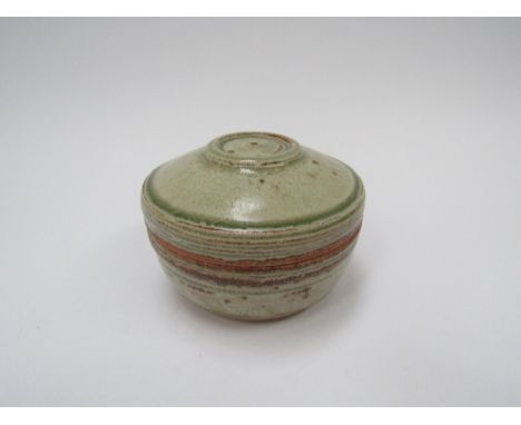 RICHARD BATTERHAM (1936-2021): A studio pottery stoneware lidded pot in green and brown ash glaze, 11cm diameter 