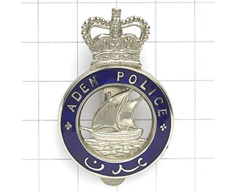 Aden Police post 1953 cap badge. Die-stamped chromed crowned blue enamel title circlet with dhow (Arab sailing ship) to voide